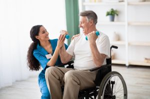 Young therapeutic recreation student in placement helping an elderly person