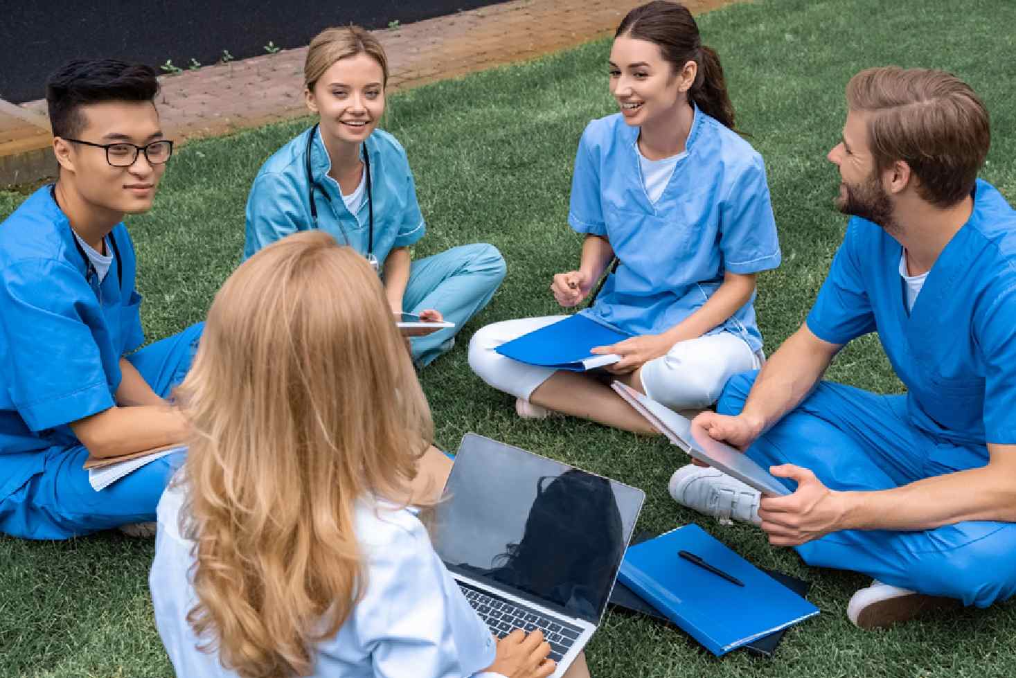A group of healthcare students post img A group of healthcare students sitting on the ground.
